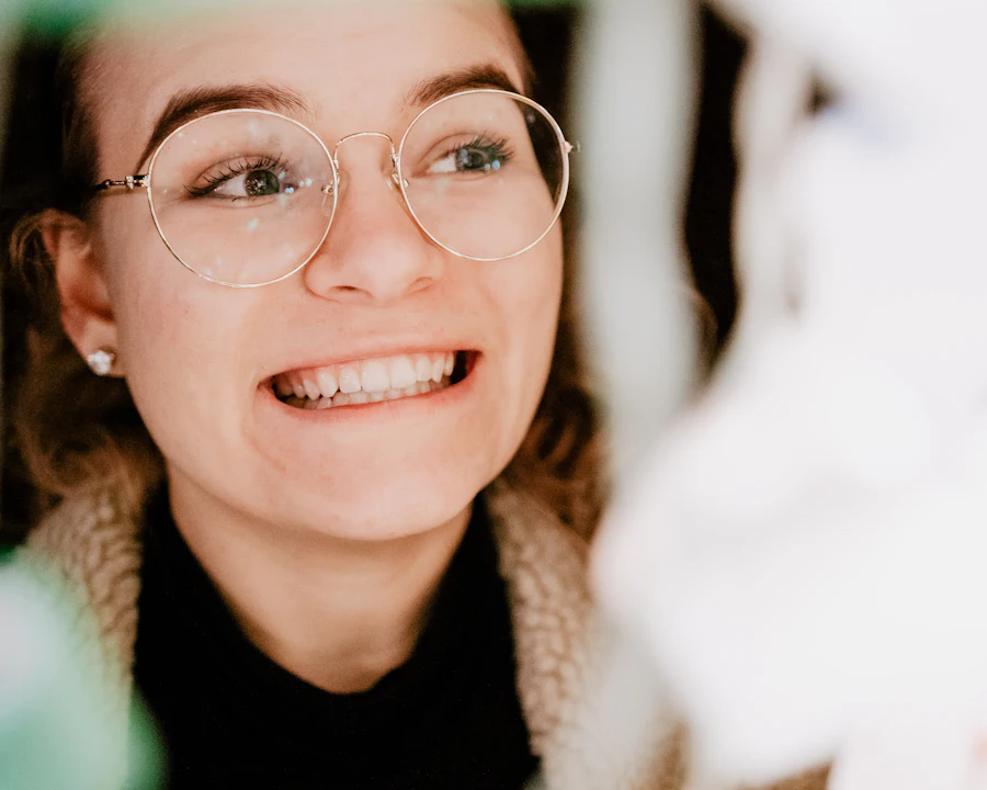 A smiling woman in round glasses